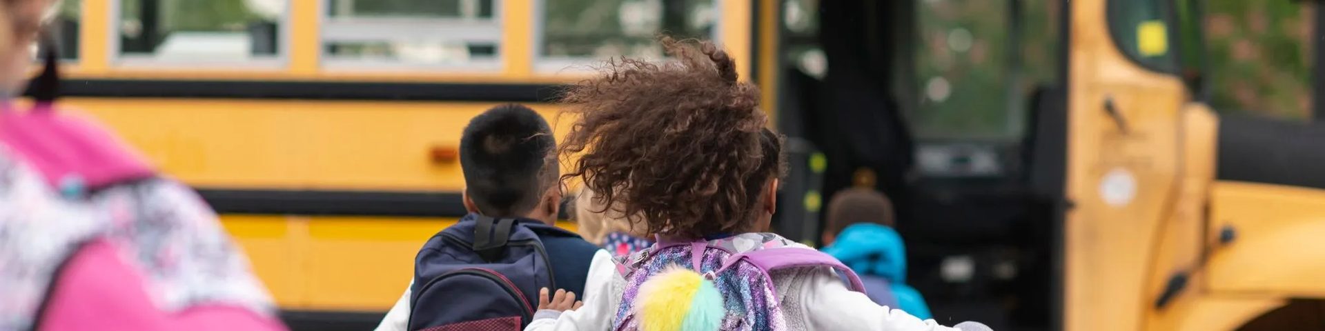 Students with backpacks heading to the school bus, one of Fullmind’s options for families.